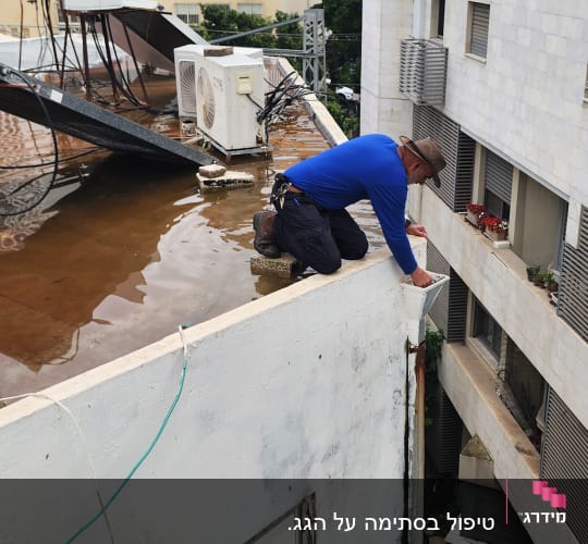 אדם עובד על גג עם מים ומזגנים